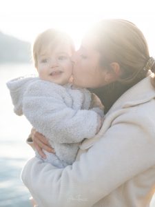 Moment de tendresse entre une mère et son enfant photographié en lumière naturelle, scène de vie familiale authentique