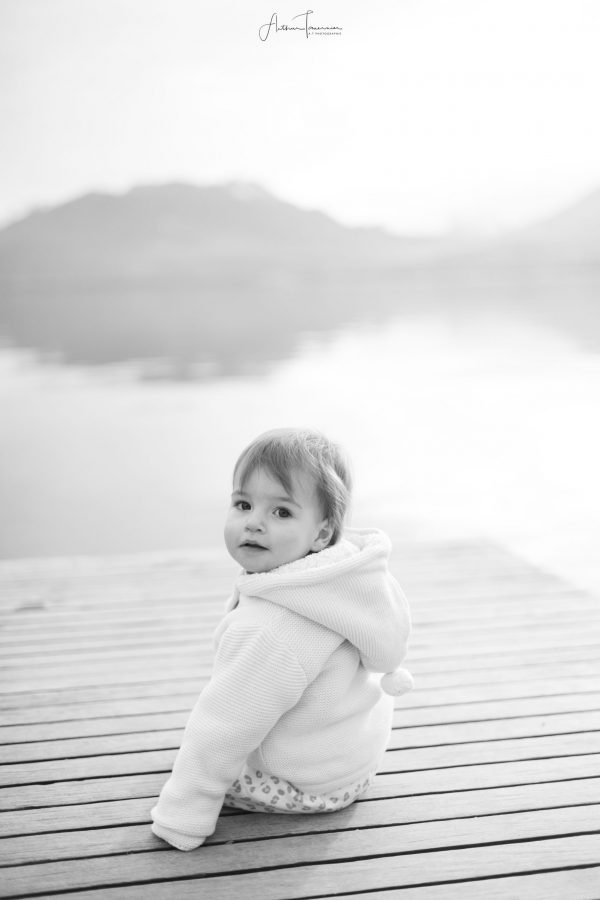 Bébé assis seul en extérieur lors d'une séance portrait à La Réunion, photographié en noir et blanc.
