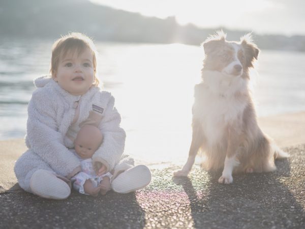 Bébé assis en extérieur à côté d'un chien lors d'une séance portrait à La Réunion, en lumière douce et naturelle.